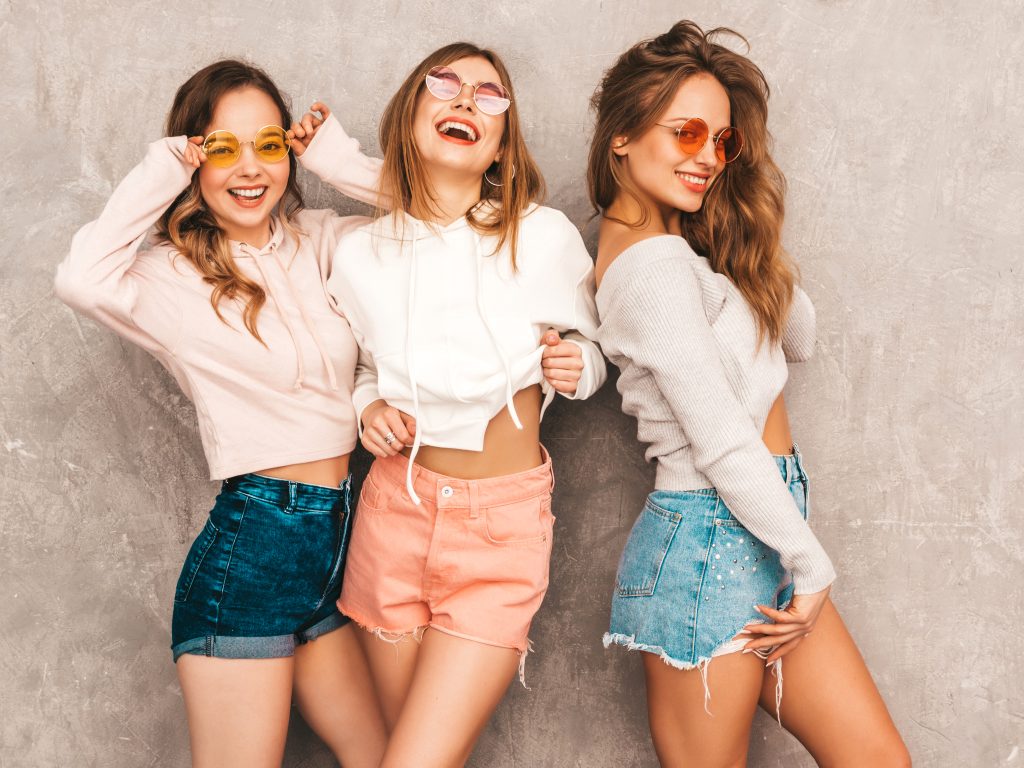 three young beautiful smiling girls trendy summer sport clothes sexy carefree women posing positive models round sunglasses having fun hugging